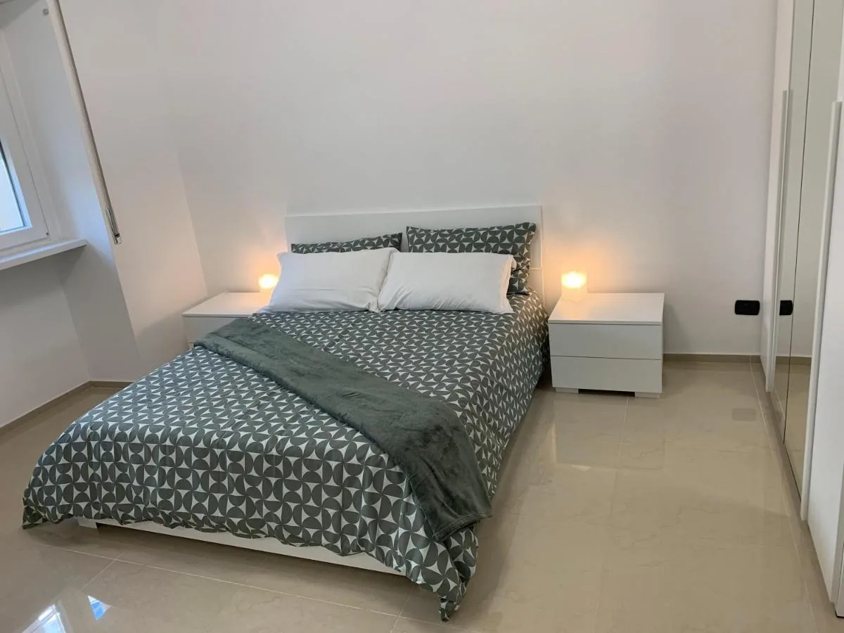 La camera da letto di A Casa di Elisa con il letto matrimoniale e le lampade accese