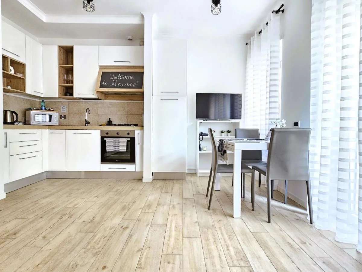 Maremè Guest House — La cucina bianca con il forno e il tavolo da pranzo